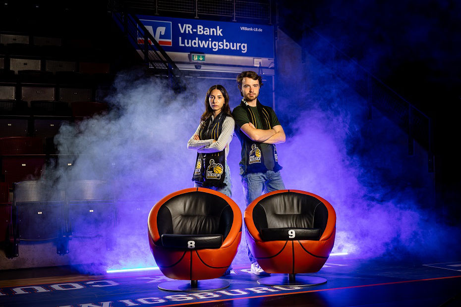 Zwei junge Fans der MHP RIESEN posieren neben Courtside-Seats