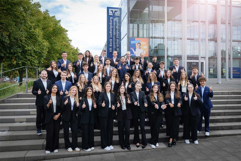 40 Auszubildende und Studierende auf der Treppe vor der Filiale der VR-Bank Ludwigsburg eG.