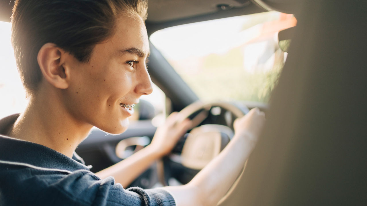 Ein Jugendlicher sitzt am Steuer eines Autos