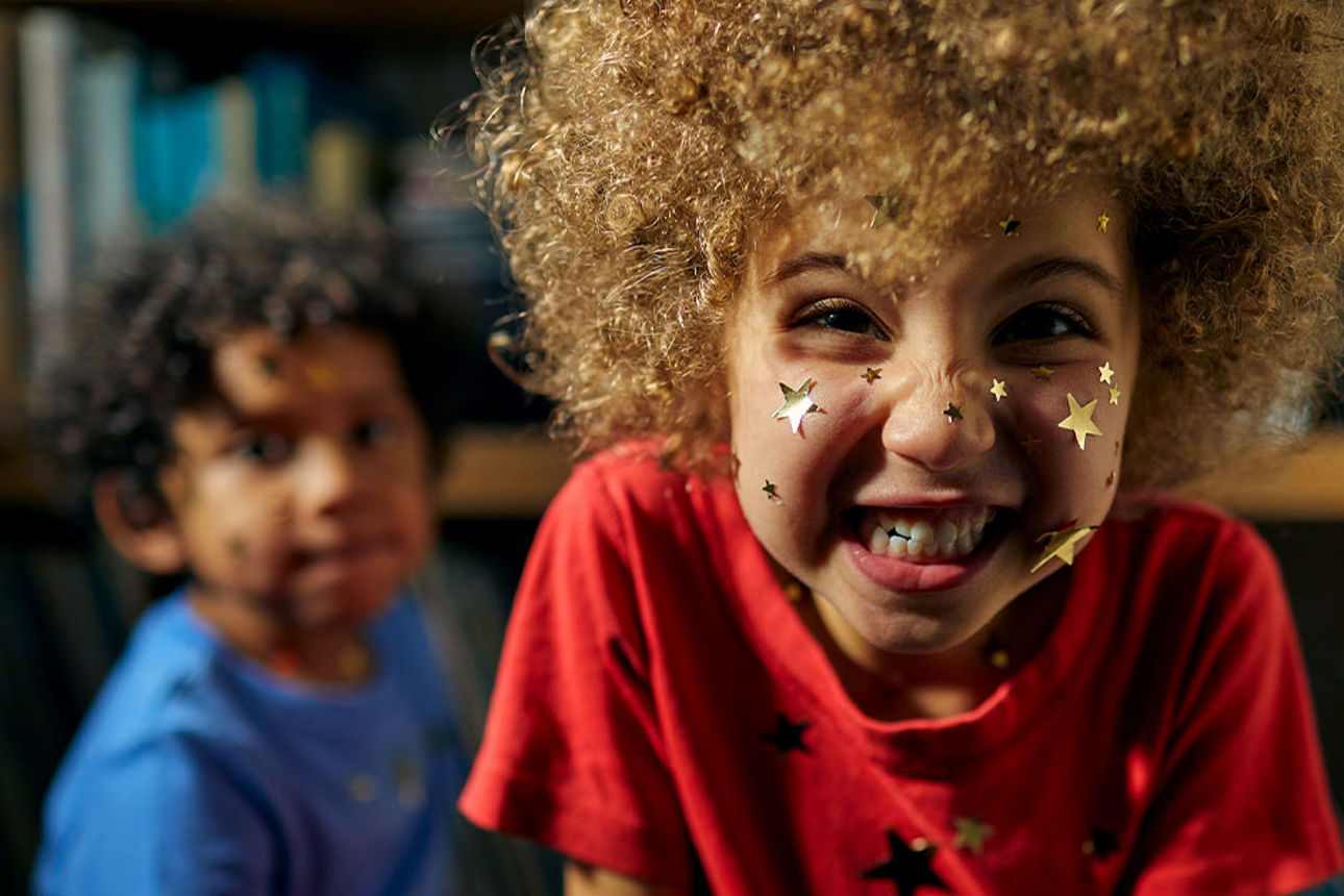 Lachendes Kind mit goldenen Sternen im Gesicht