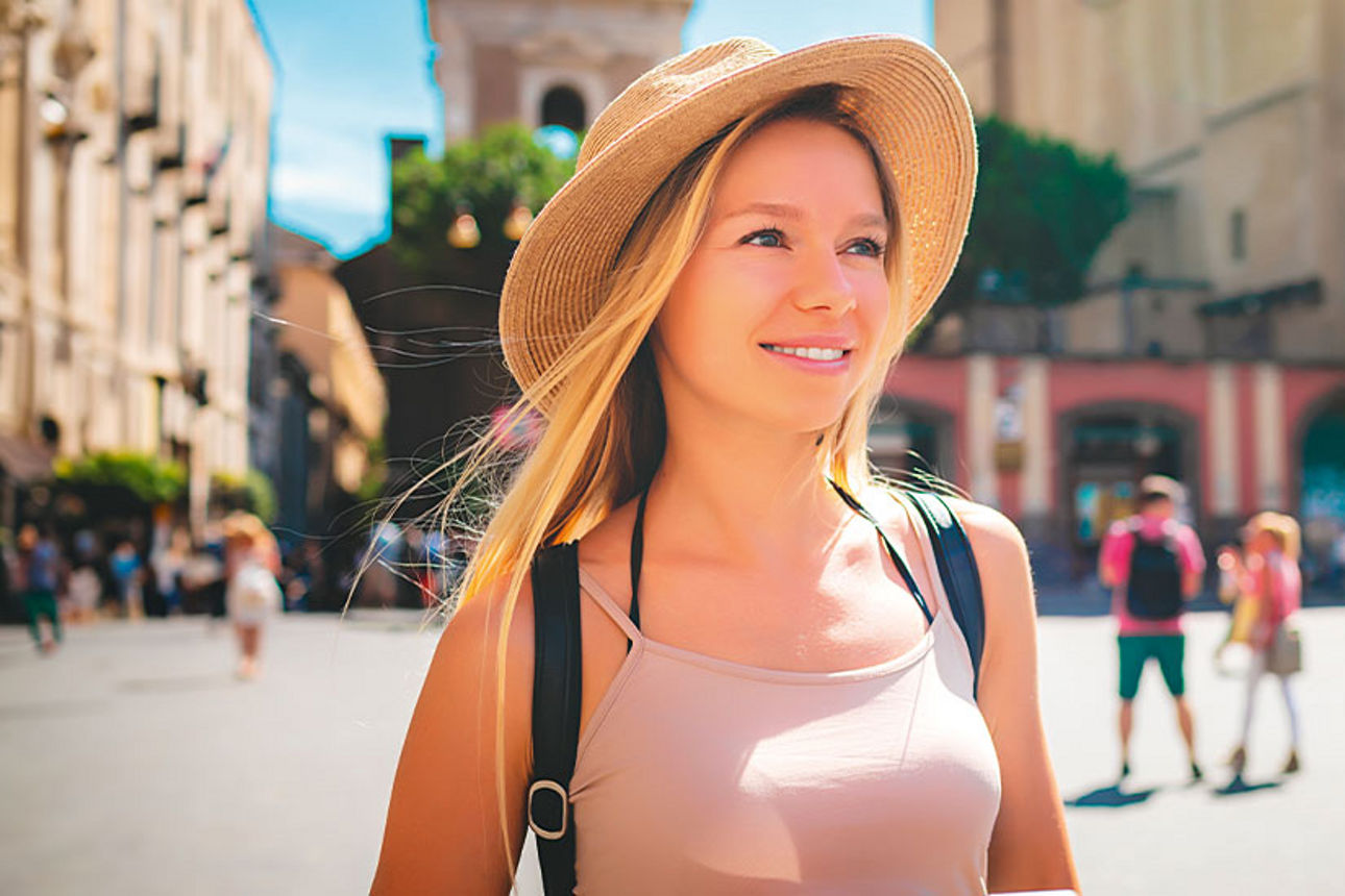 Junge Frau mit Hut und Rucksack