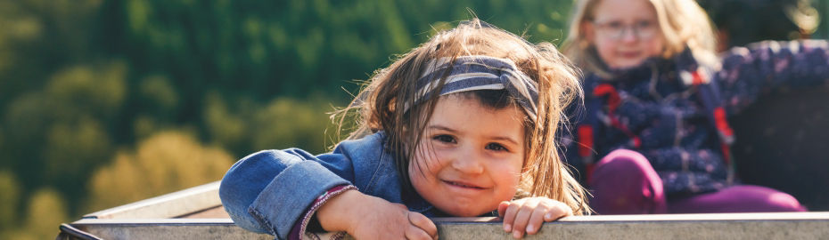 Zwei Kinder sitzen in deinem Traktoranhänger.