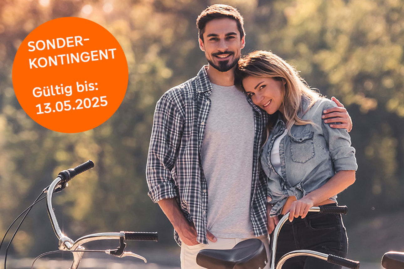 Ein lächelndes Paar mit einem Tandem in der Natur