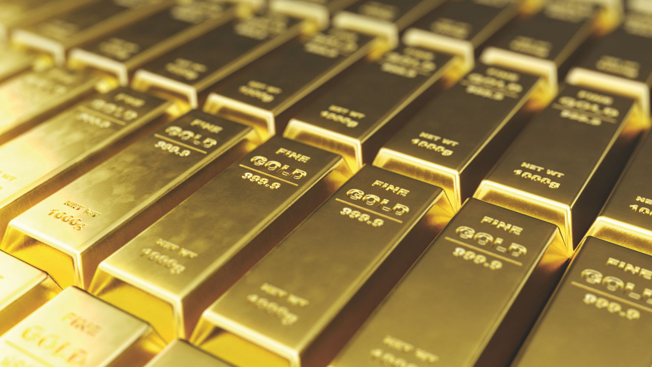 Mehrere Goldbarren liegen dicht nebeneinander in der Reihe und glänzen im Licht.
