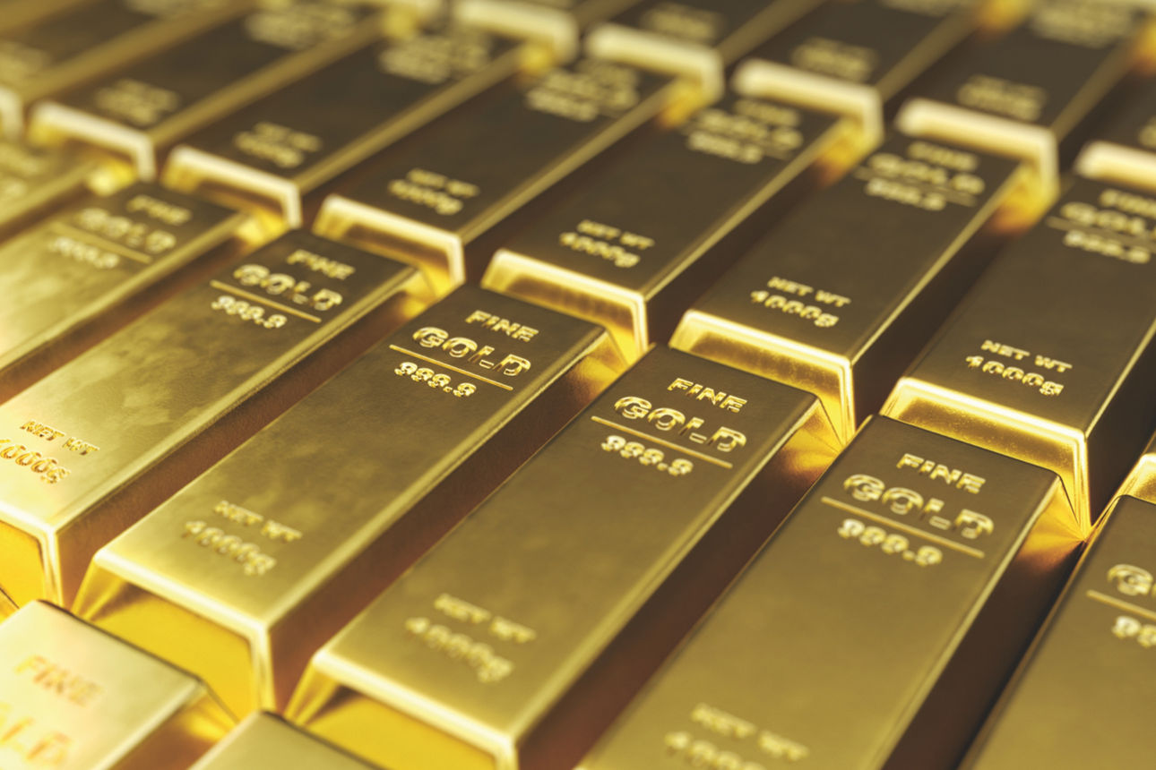 Mehrere Goldbarren liegen dicht nebeneinander in der Reihe und glänzen im Licht.