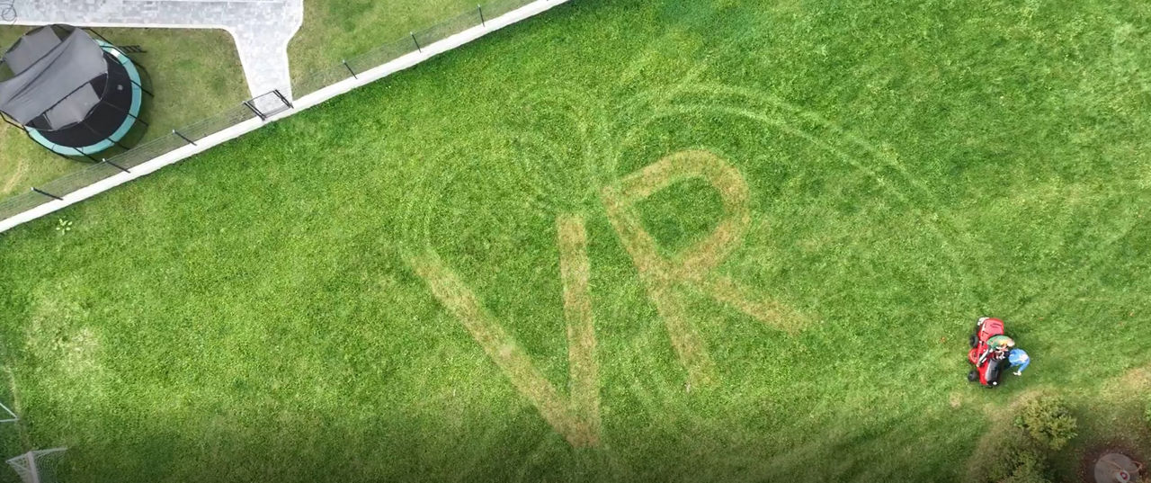 VR-Zeichen mit Rasenmähertraktor in Wiese gemäht