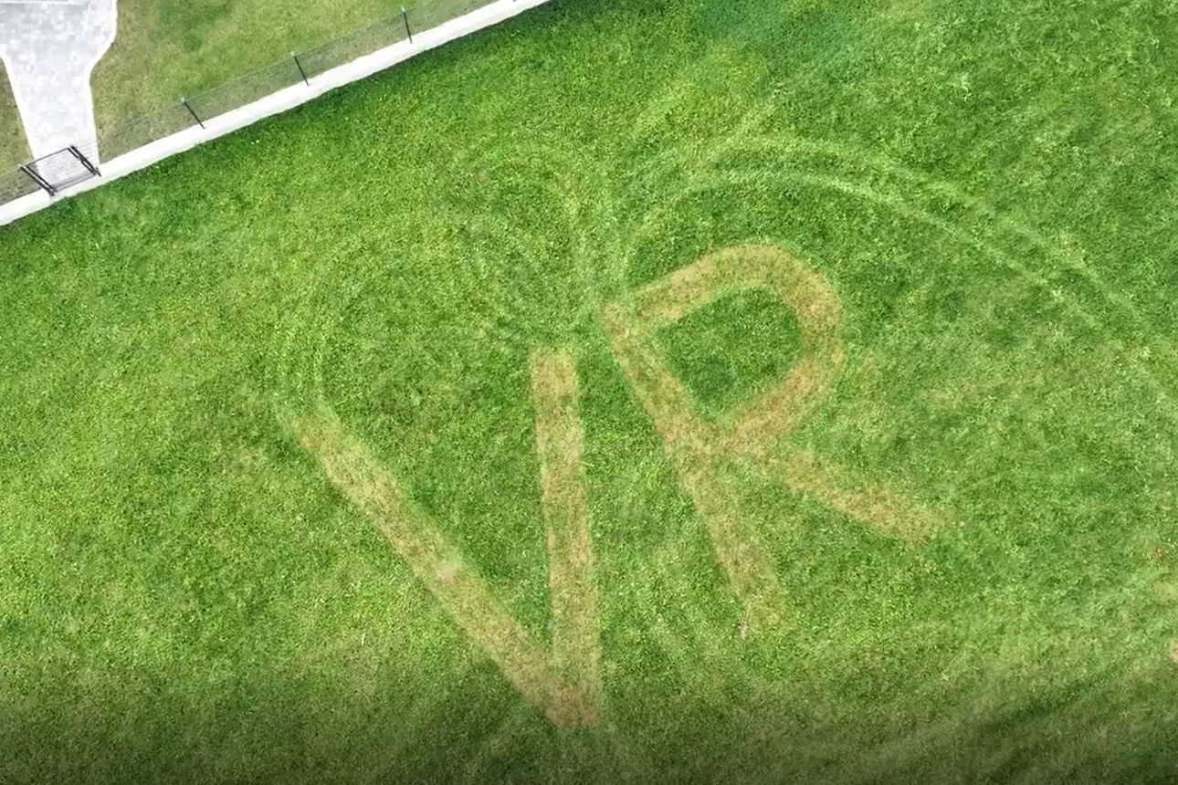 VR-Zeichen mit Rasenmähertraktor in Wiese gemäht