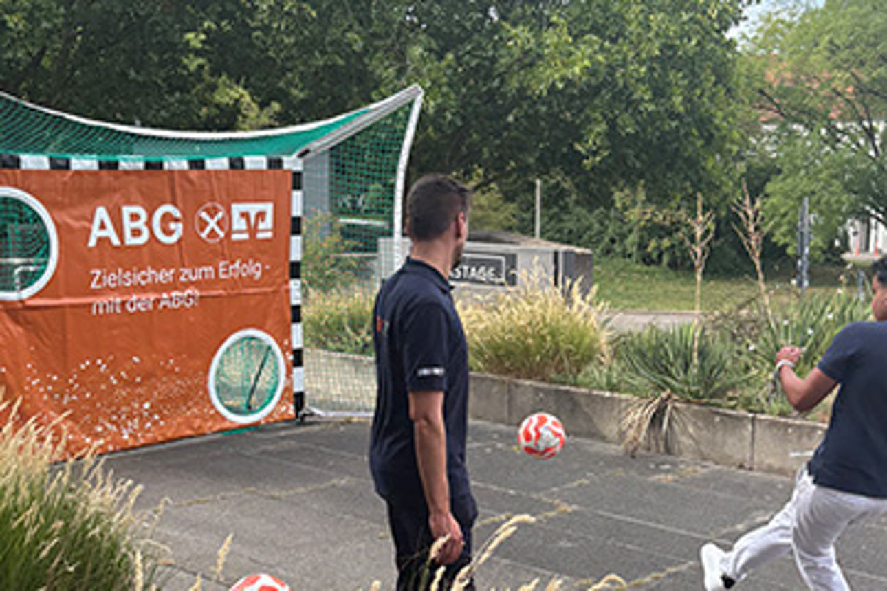 Ein Mann schießt einen Fußball auf eine Torwand