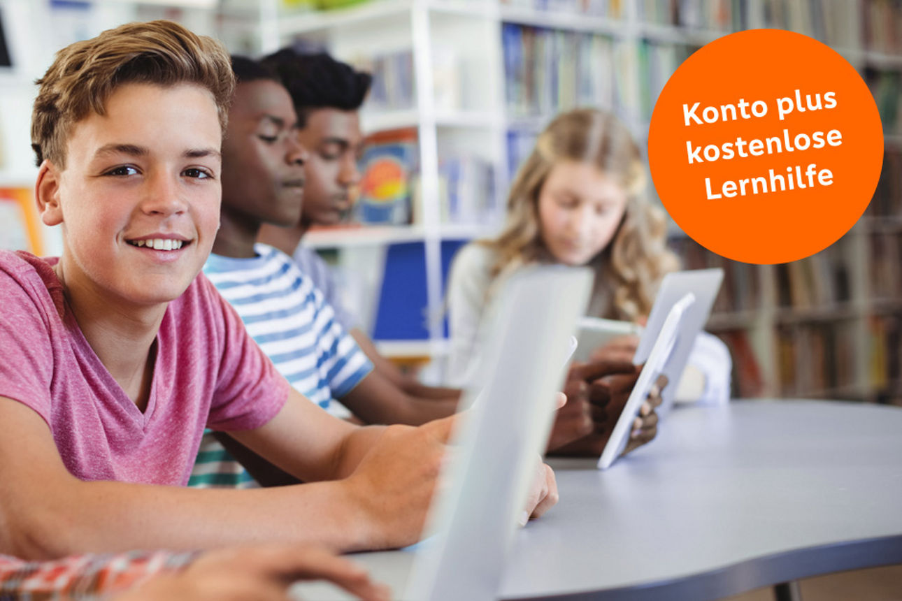 Schülerinnen und Schüler sitzen lächelnd in einem Klassenraum
