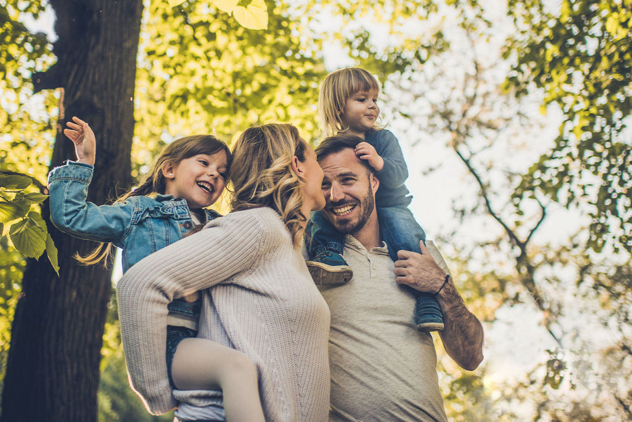 Eine Familie steht lächelnd in der Natur