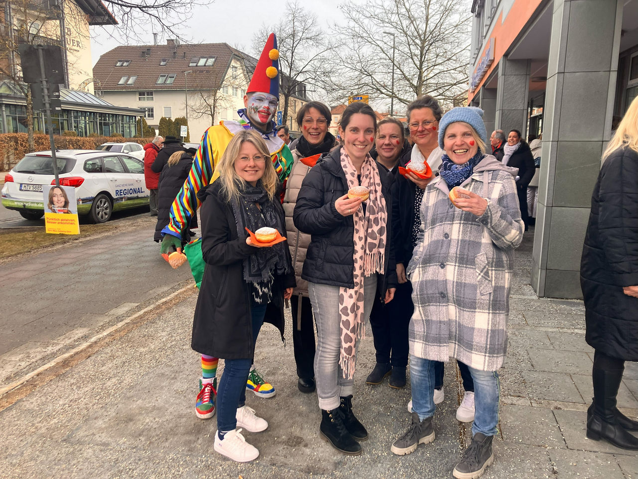 Die Menschen vo Ort freuen sich über die Schäfflertänze vor der Filiale VR Bank München Land eG Feldkirchen