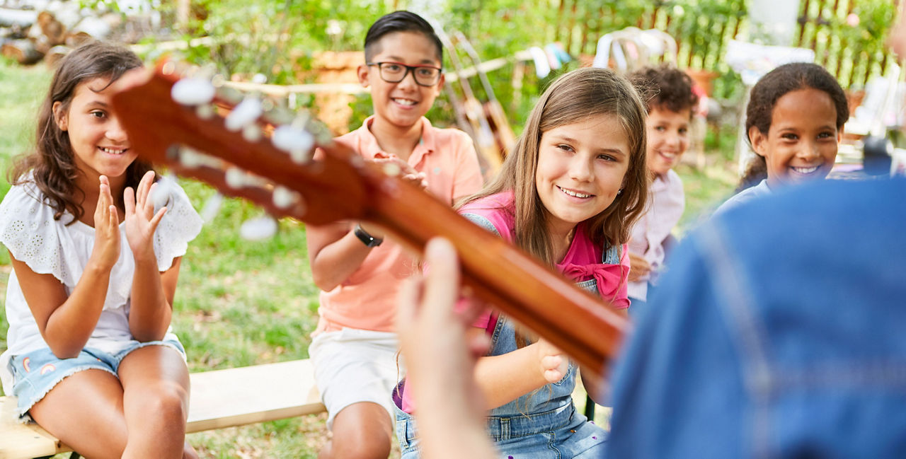 Kinder sitzen geminsam im Garten