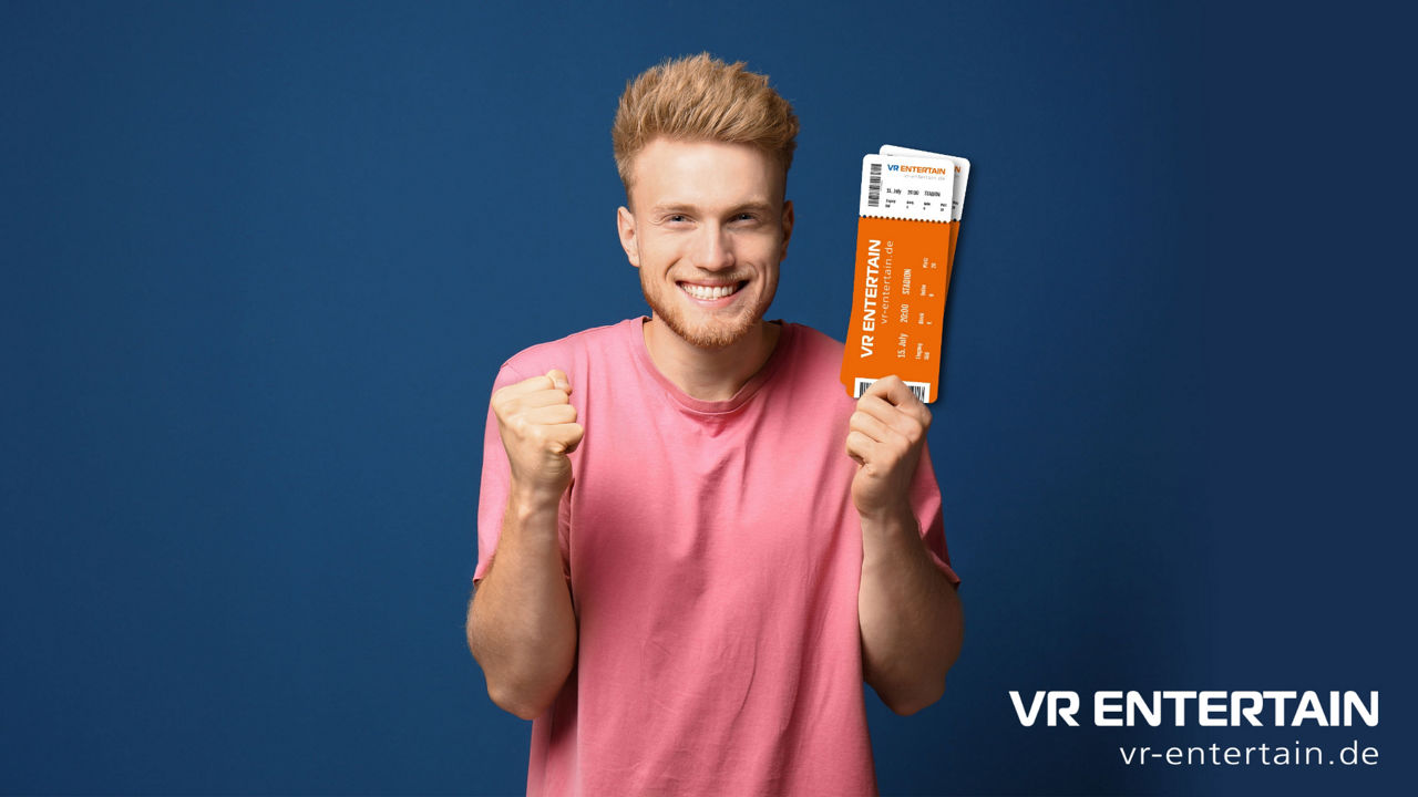 Fröhlicher junger Mann hält Tickets von VR ENTERTAIN in der Hand