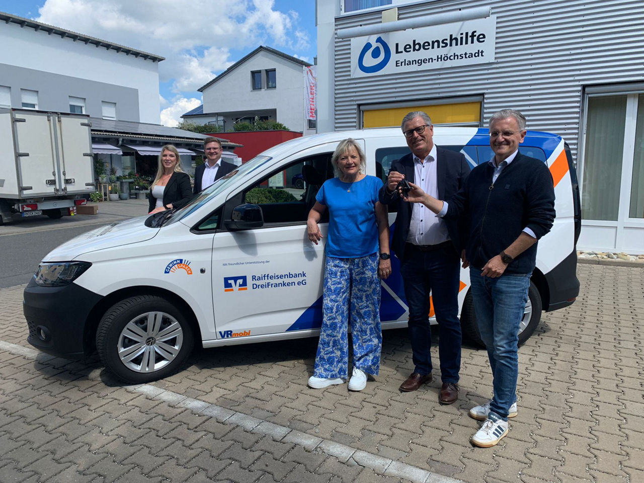 Fröhliche Erwachesene stehen bei VRmobil der Lebenshilfe.