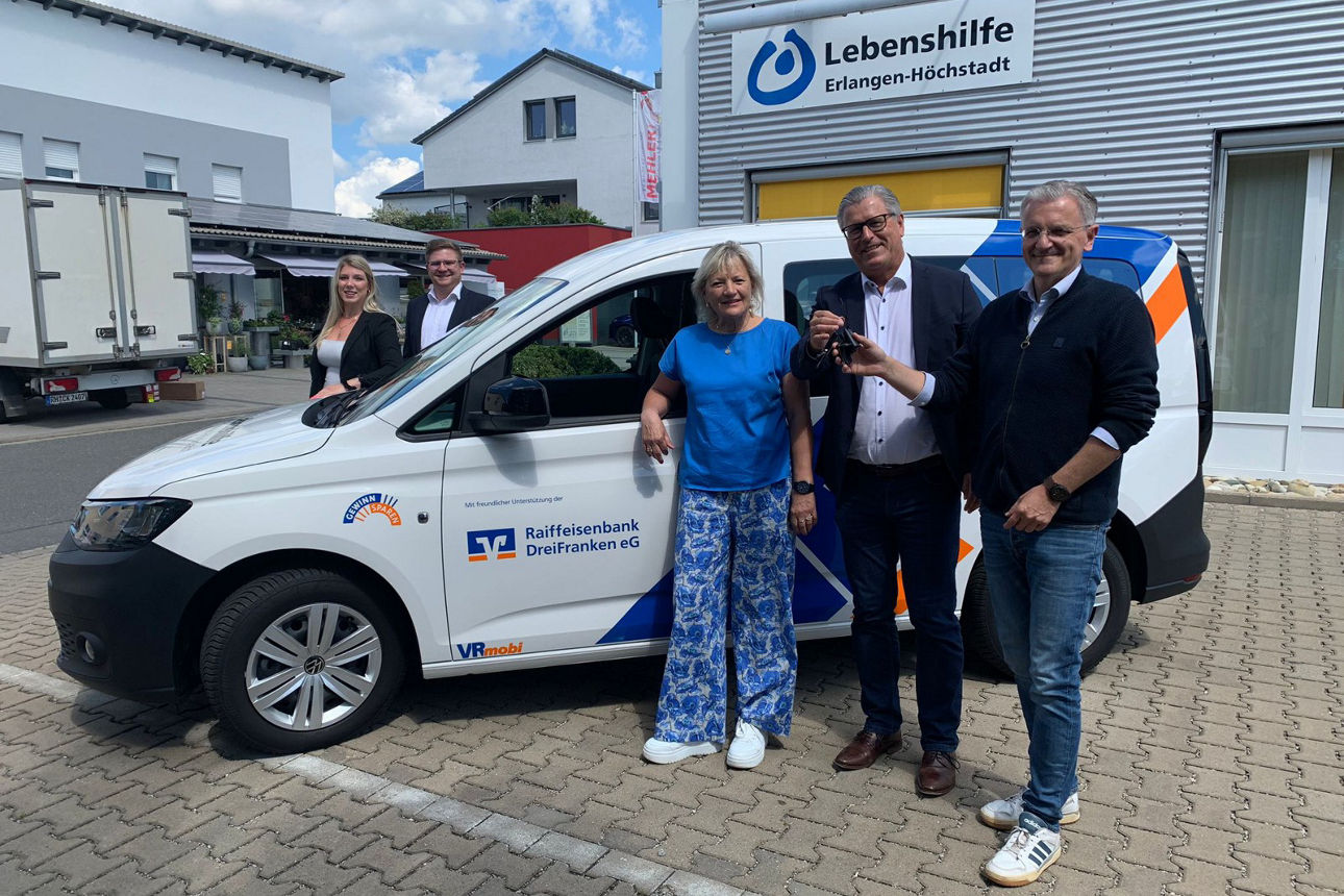 Fröhliche Erwachesene stehen bei VRmobil der Lebenshilfe.