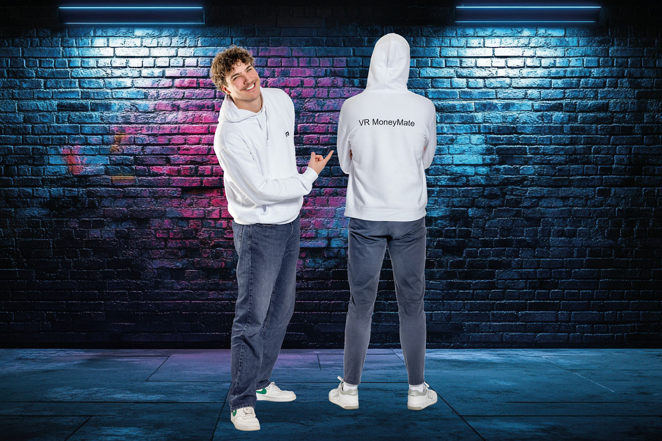 Zwei junge Männer in weißen Hoodies stehen vor einer Grafiti-Wand.