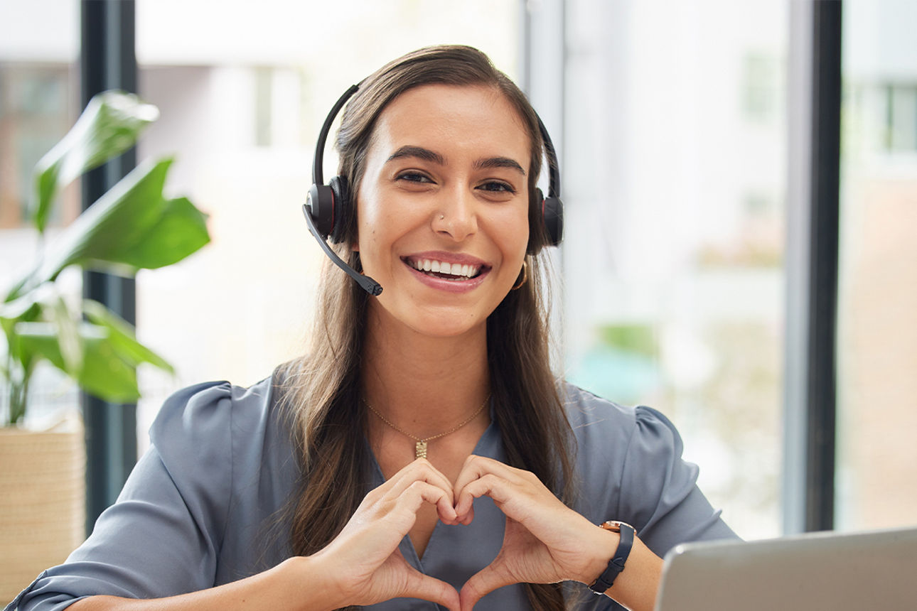 Weibliche Servicekraft mit Headset lächelt in die Kamera