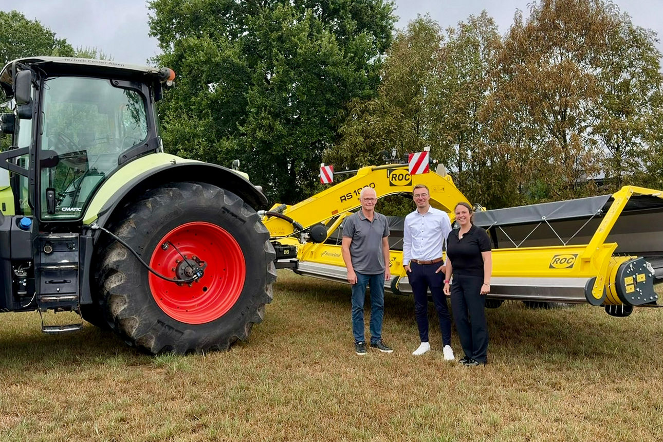 Drei Personen stehen vor einen Traktor 