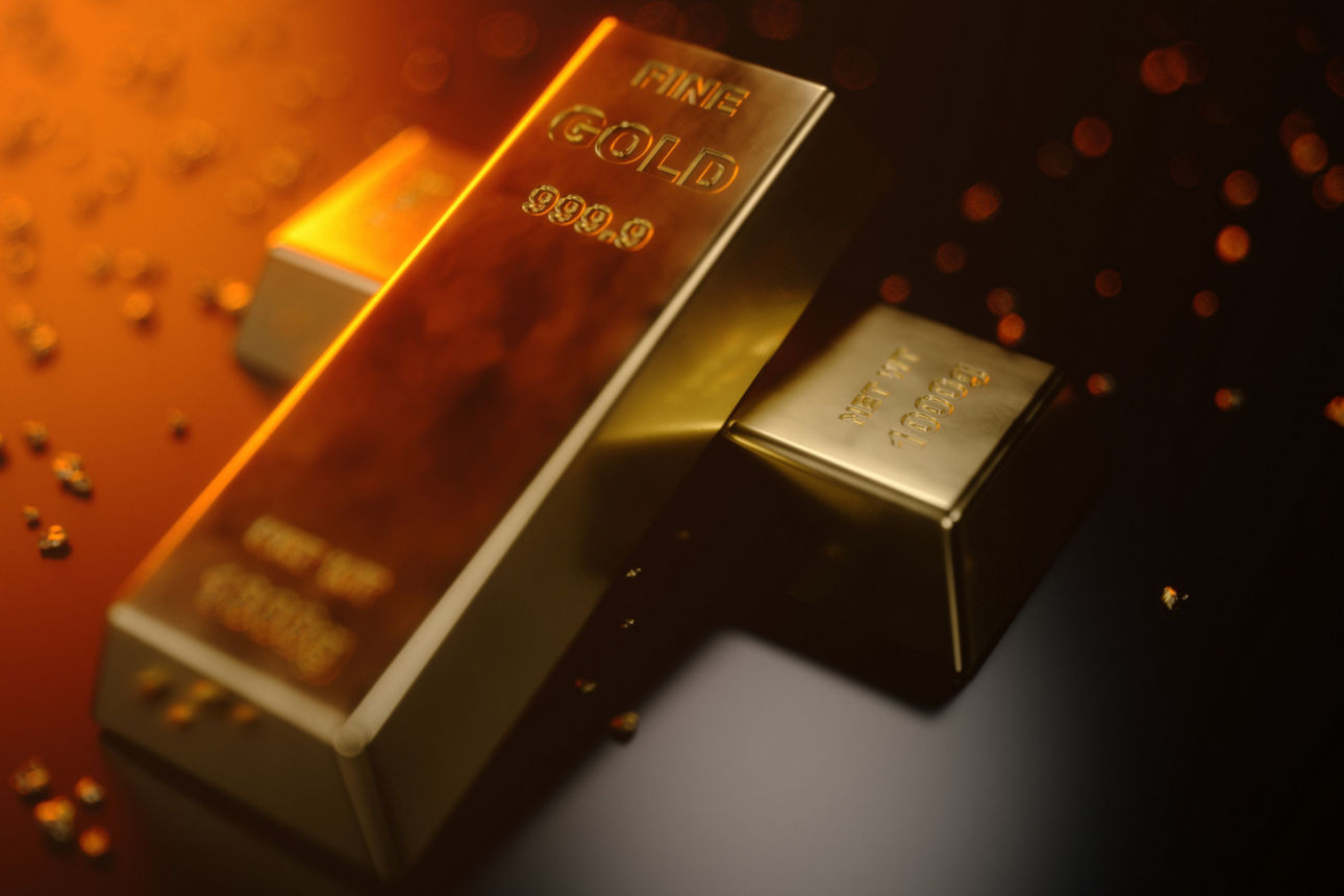 Zwei Goldbarren liegen versetzt übereinander auf einem dunklen Untergrund. 