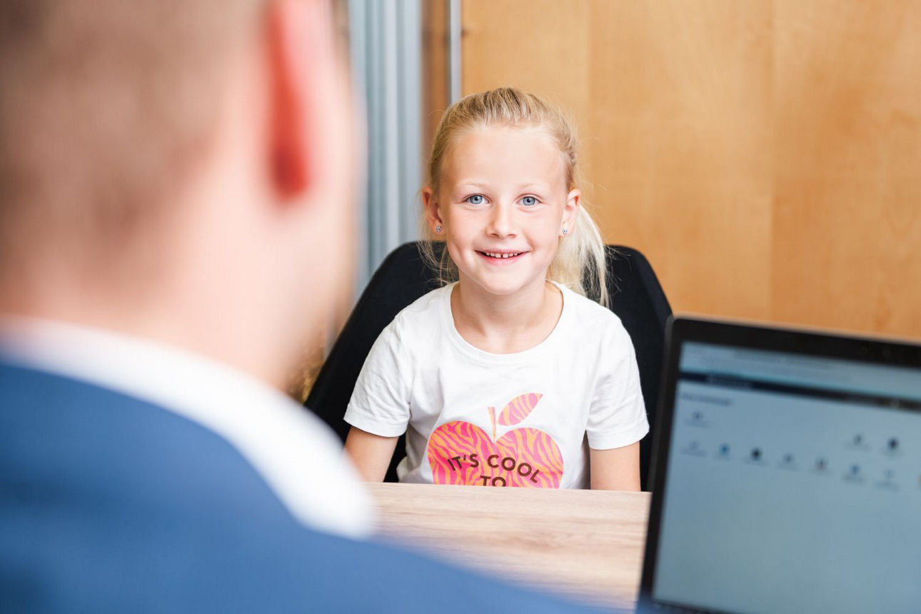 Lächelndes Mädchen auf Schreibtischstuhl