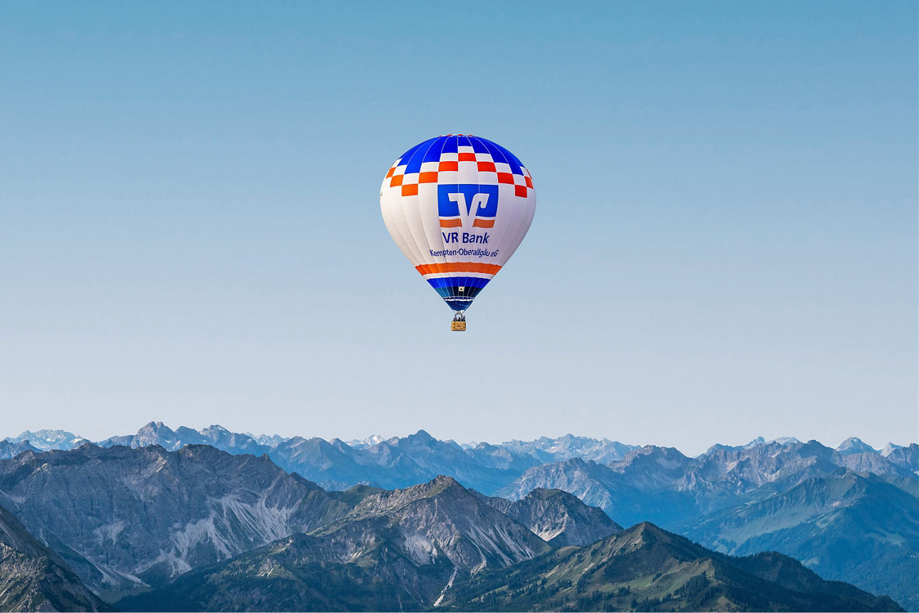 Heißluftballon der VR Bank Kempten-Oberallgäu eG startet von einer Wiese in der Nähe von Burgberg