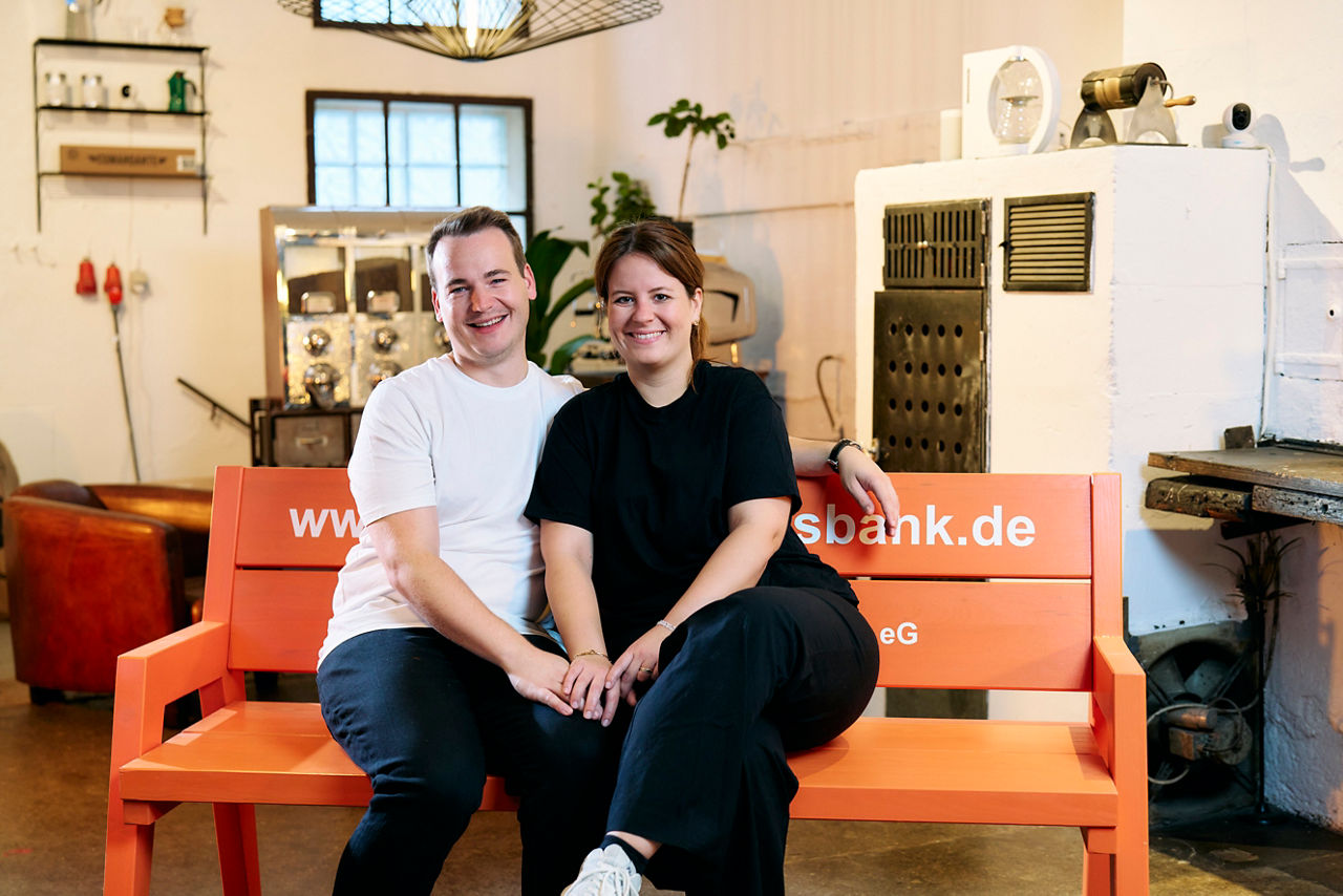 Marius Geiselhart und seine Frau sitzen auf einer orangen Bank