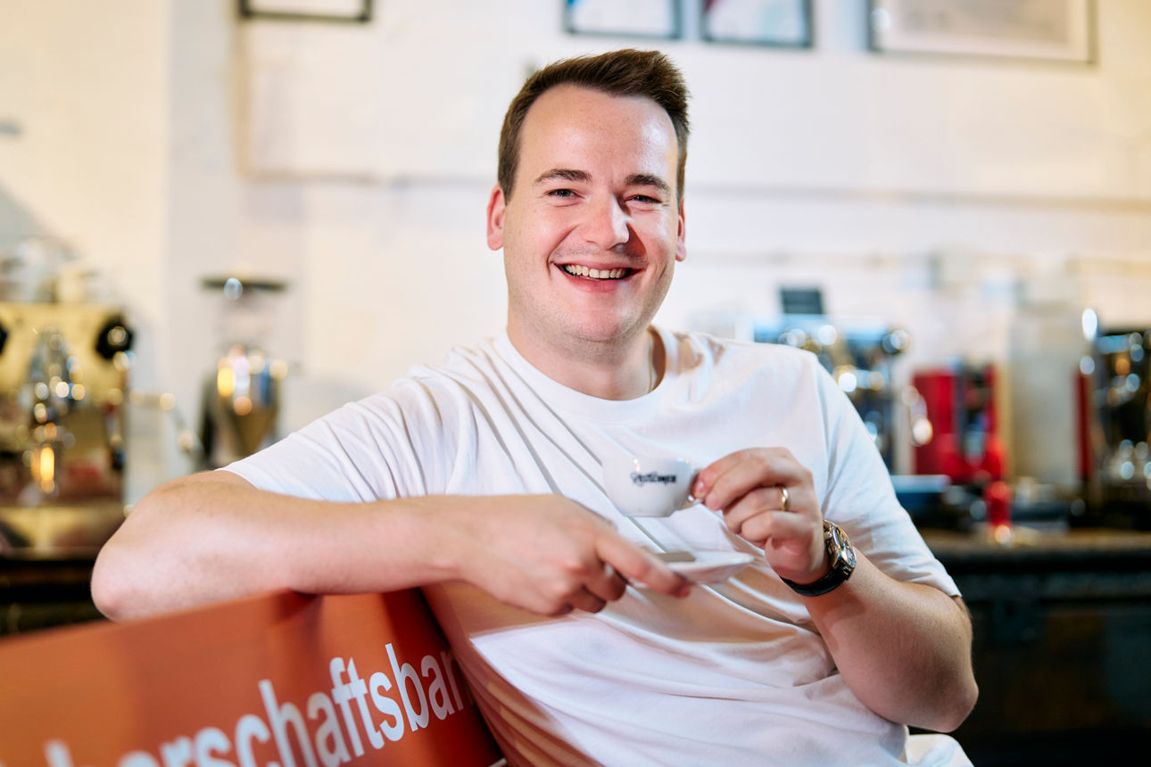 Marius Geiselhart sitzt in der Röstschmiede und trinkt einen Kaffee