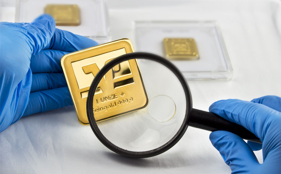 Lupe, die einen Goldbarren prüft und vergrößert