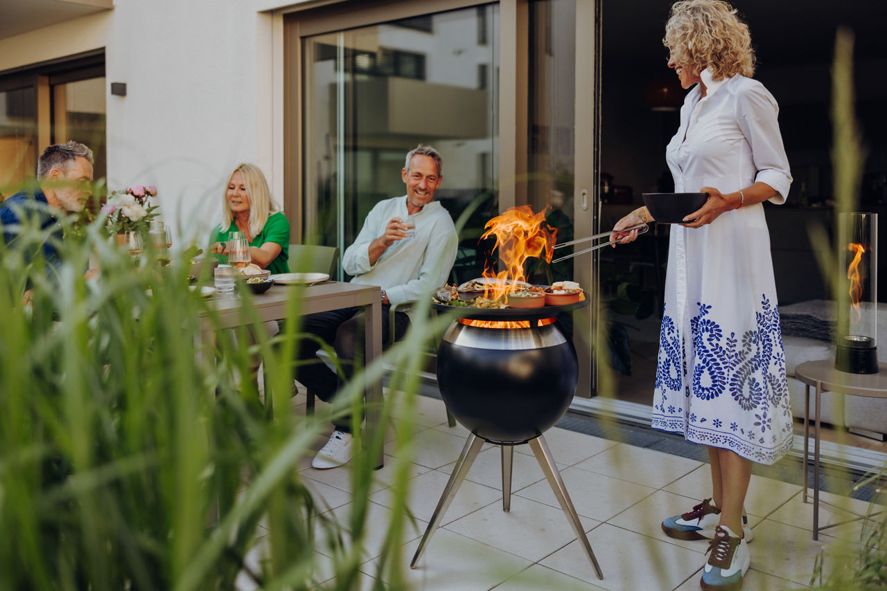 Mehrere Personen beim Grillen auf der Terasse