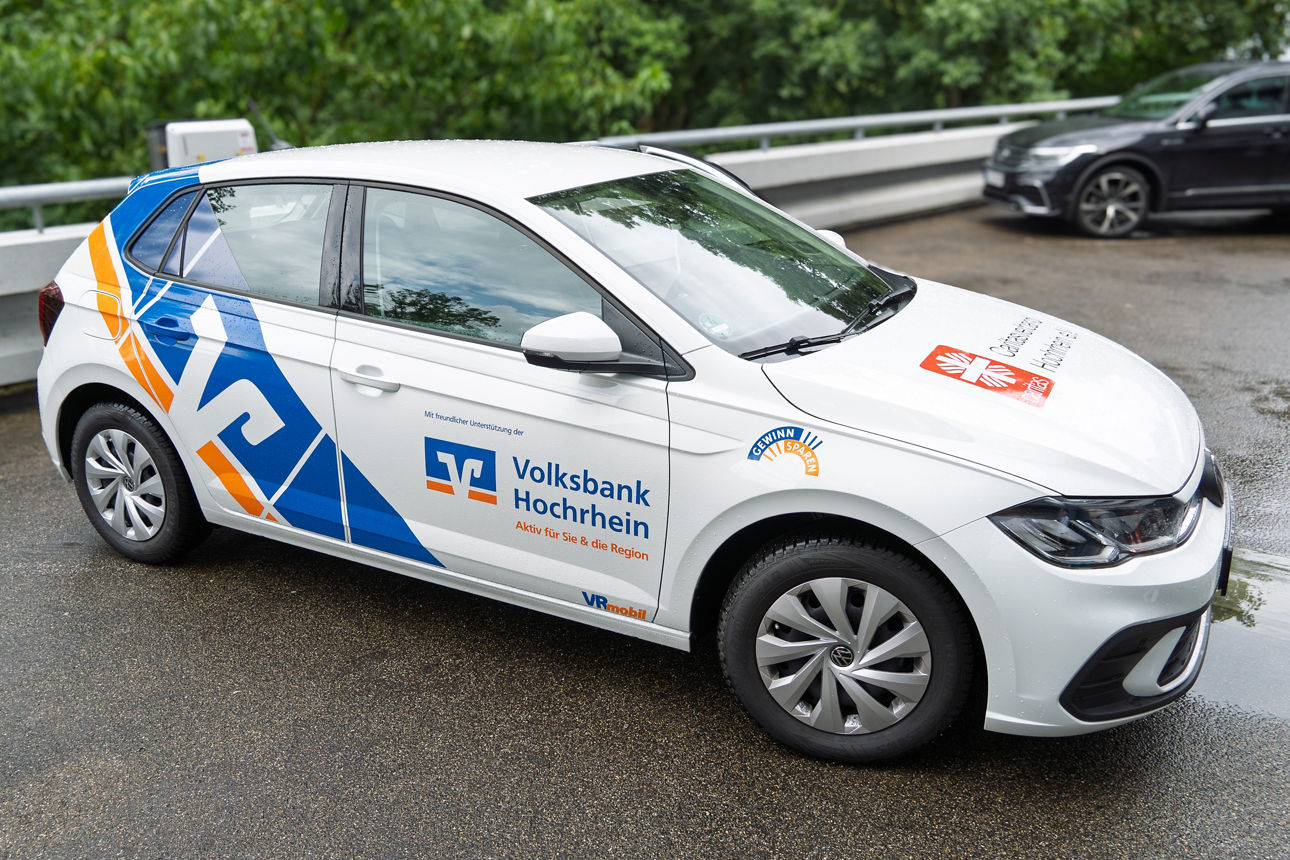 Ein weißer Kleinwagen im Volksbanken Design.