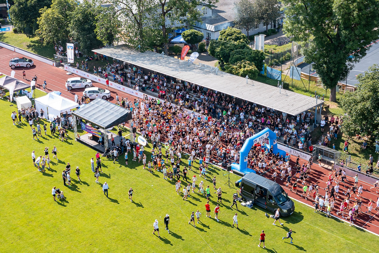 Viele Menschen stehen auf einem Sportplatz für ein Laufevent