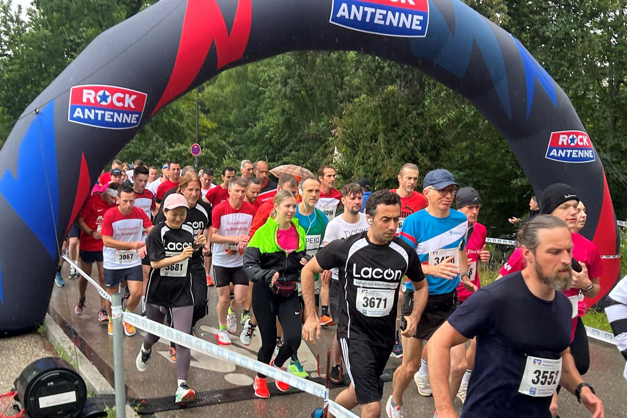 Viele Läufer laufen durch ein Tor bei einem Laufevent