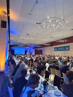 Ein großer Konferenzraum, gefüllt mit Teilnehmern.
