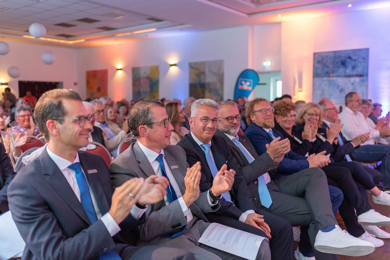 Vorstand und Aufsichtsrat sitzen entlang einer langen Reihe.