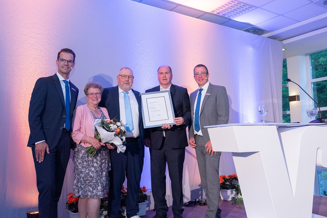 Gratulation mit Brief zur silbernen Ehrennadel für Eduard Kolkmann. Stefan Korte, Frau Kolkmann mit Blumen in der Hand, Laudatio Carsten Waldhelm und Norbert Scholtholt