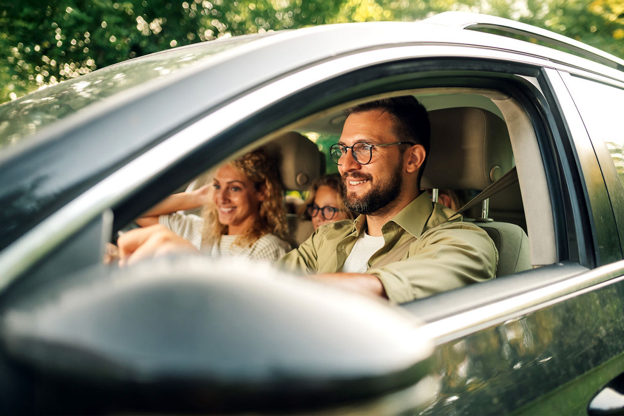 Vater, Mutter und Tochter fahren in ihrem neuen Auto