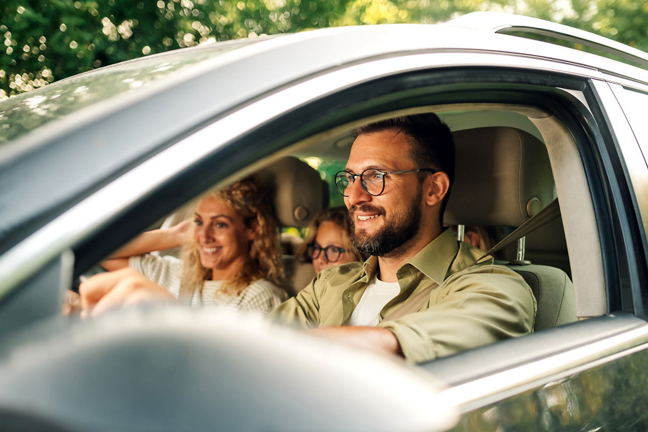 Vater, Mutter und Tochter fahren in ihrem neuen Auto
