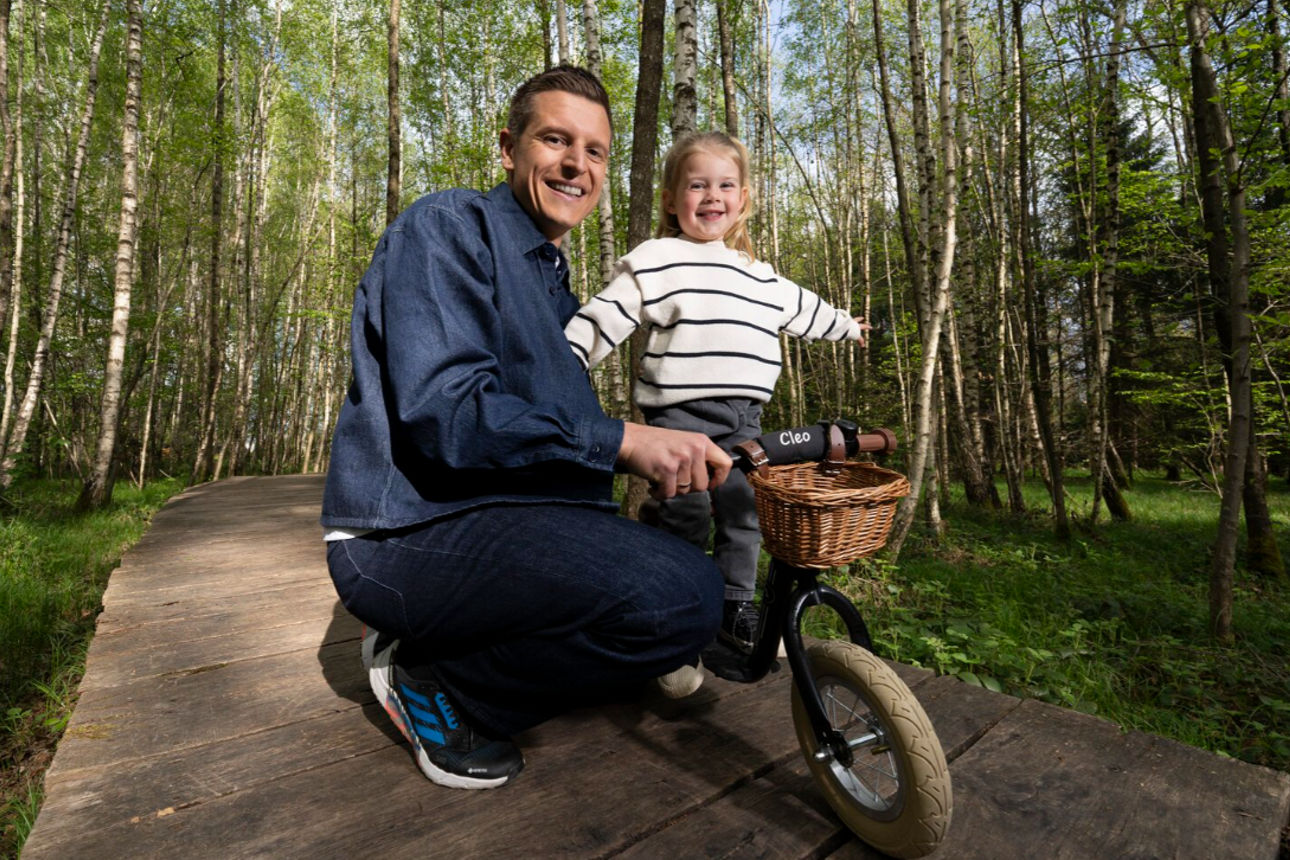 Vater hält seine Tochter auf dem Fahrrad