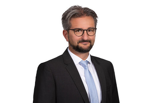 Freundlich lächelnder Mann im Anzug, unser Geschäftsführer des ImmoZentrums David Velat