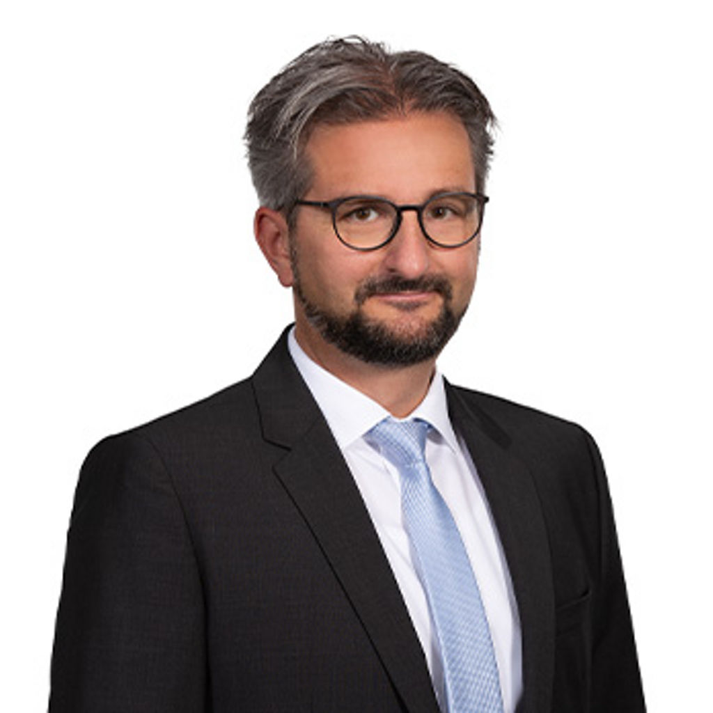 Freundlich lächelnder Mann im Anzug, unser Geschäftsführer des ImmoZentrums David Velat