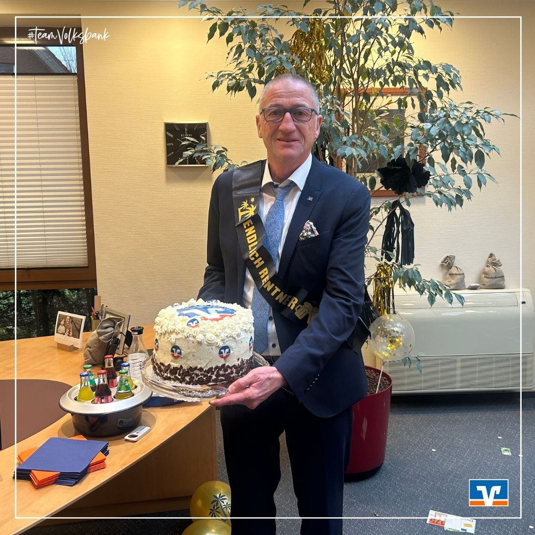 Ein Mann mit Brille hält eine Torte in der Hand
