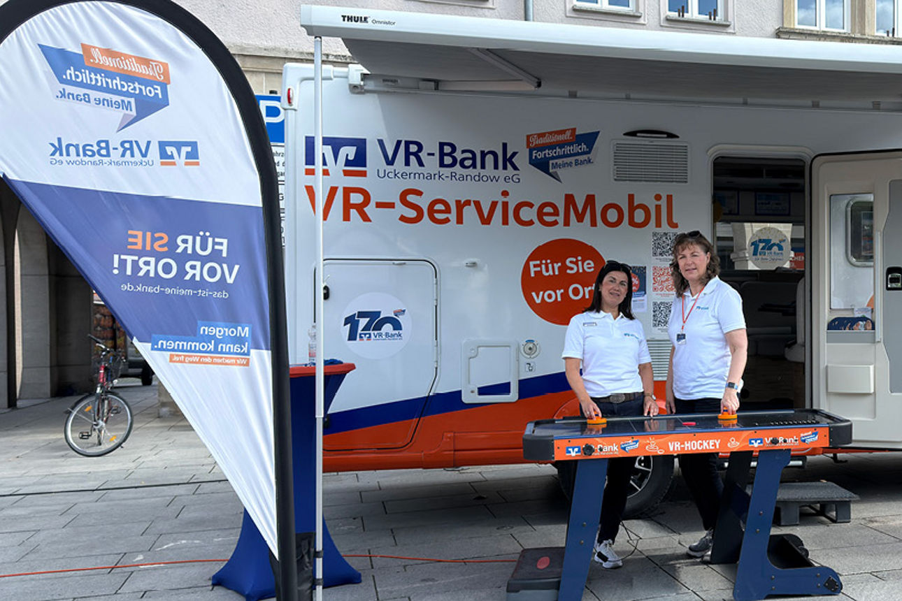 Zwei VR-Bank Mitarbeiter stehen vor dem VR-ServiceMobil