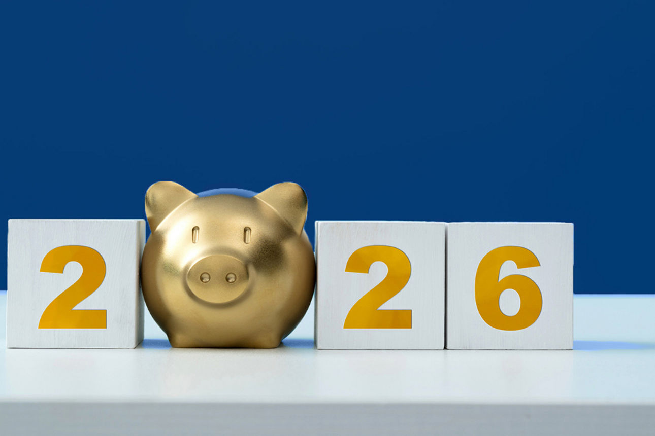 Die Jahreszahl 2026 vor blauem Hintergrund, ein goldenes Sparschwein ersetzt die Null