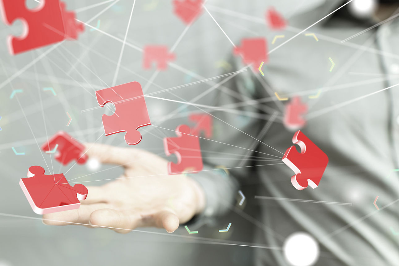 Rote Puzzleteile fliegen über einer ausgestreckten Hand.