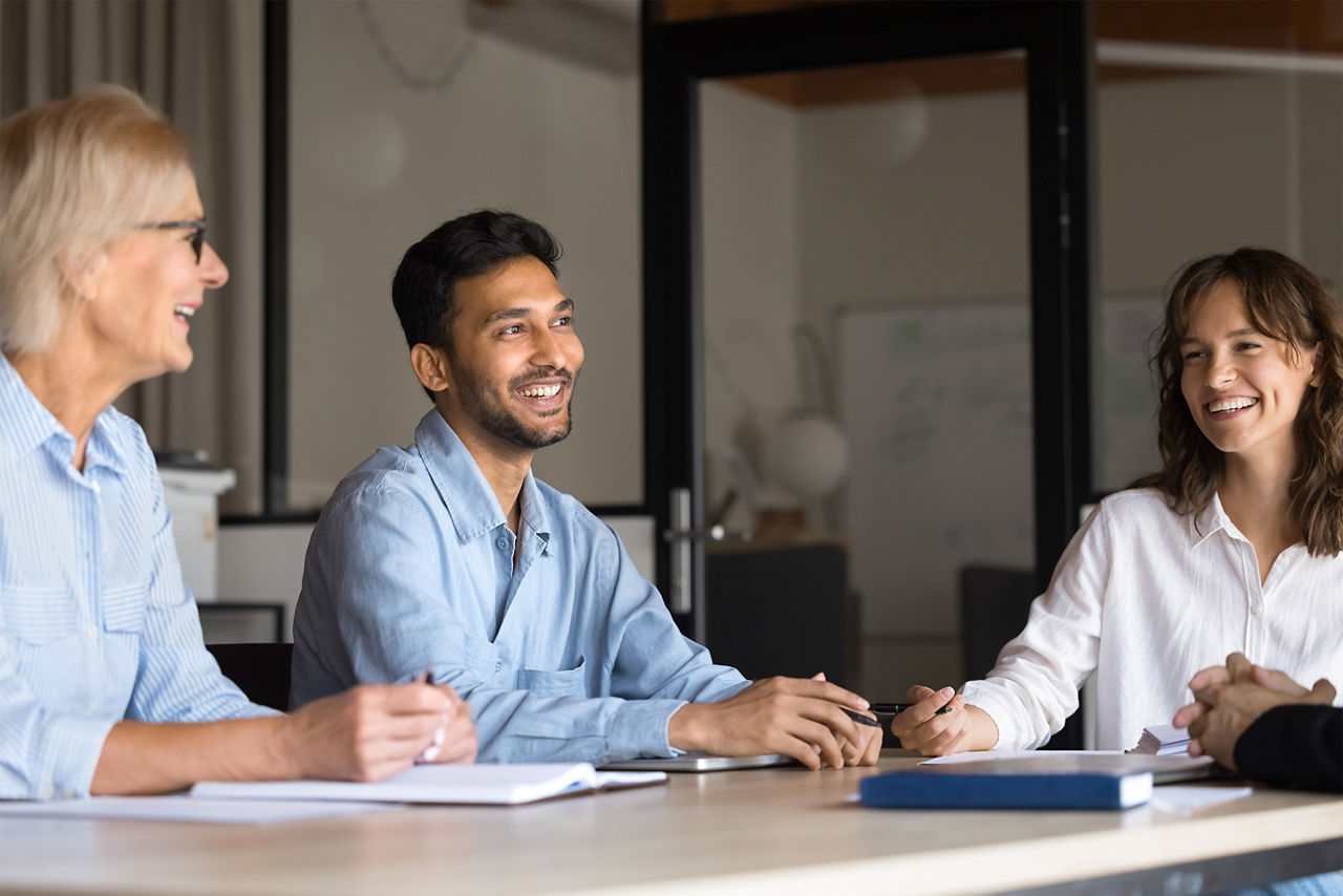 Zwei Frauen und eihn Mann sitzen in einem Meeting 