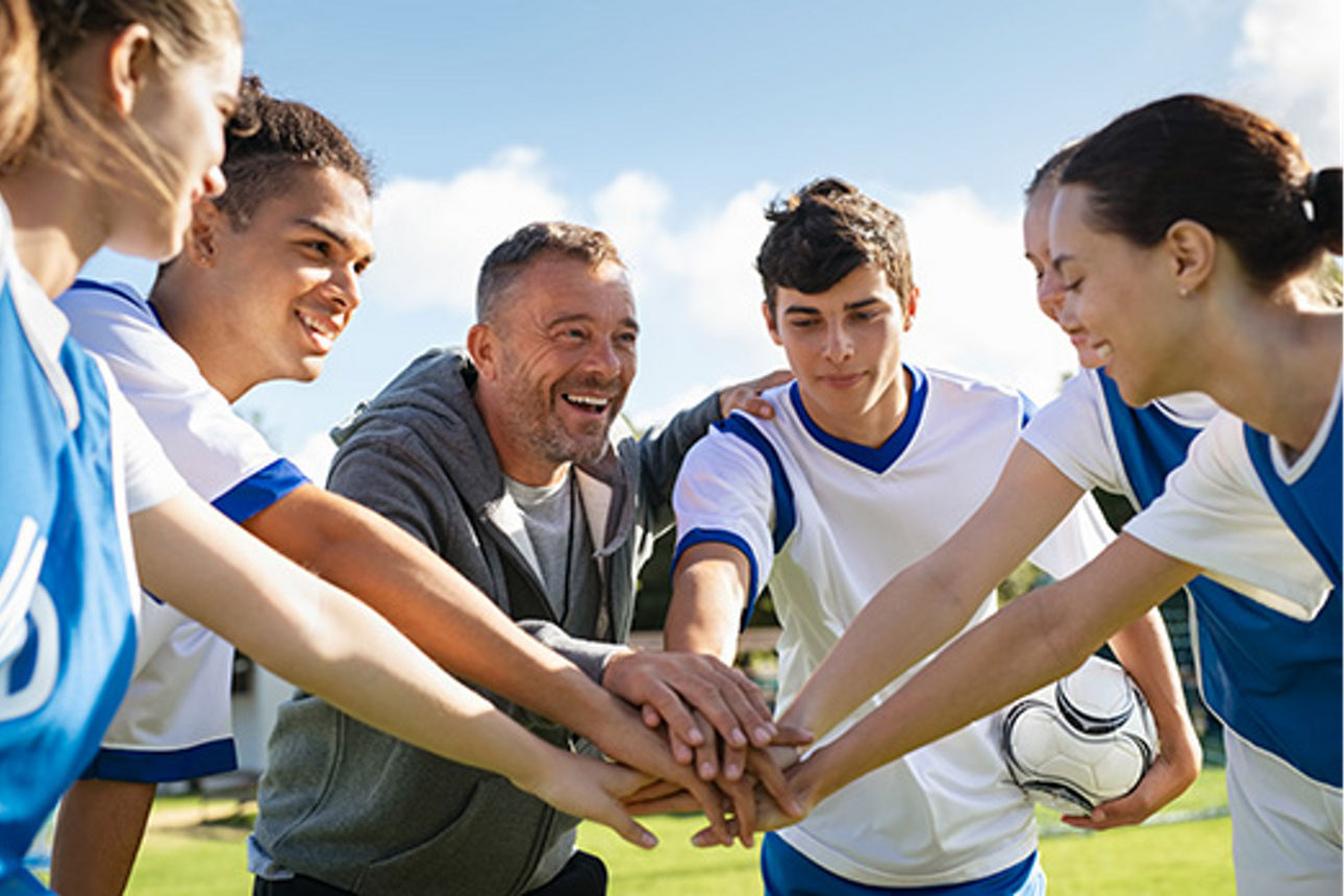 Drei Personen stehen lachend vor dem Schriftzug „Wir sind meine Bank.“