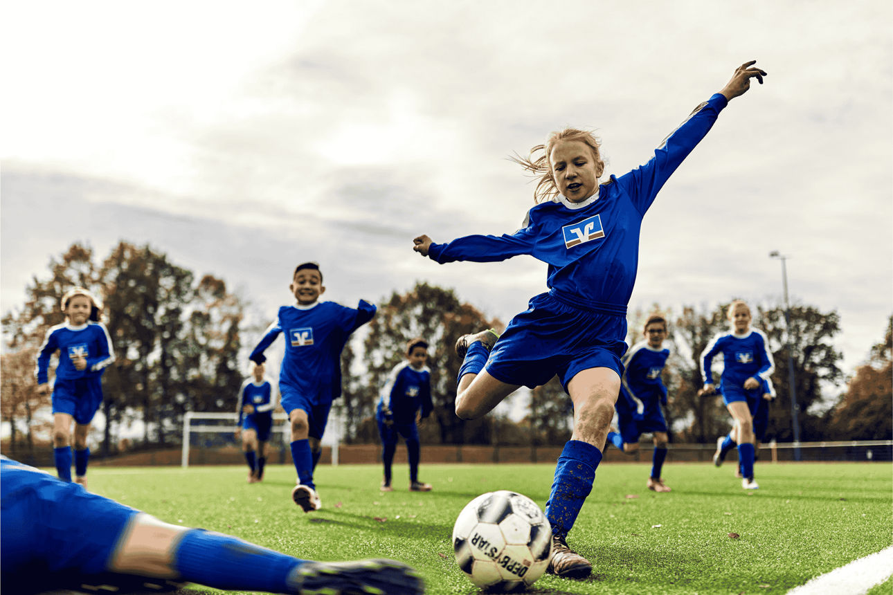 Mädchen in VR-Fußball-Outfit schießt einen Fußball