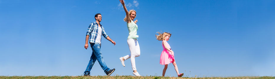 Eine fröhliche Familie springt an einem hellen Tag gemeinsam in die Luft