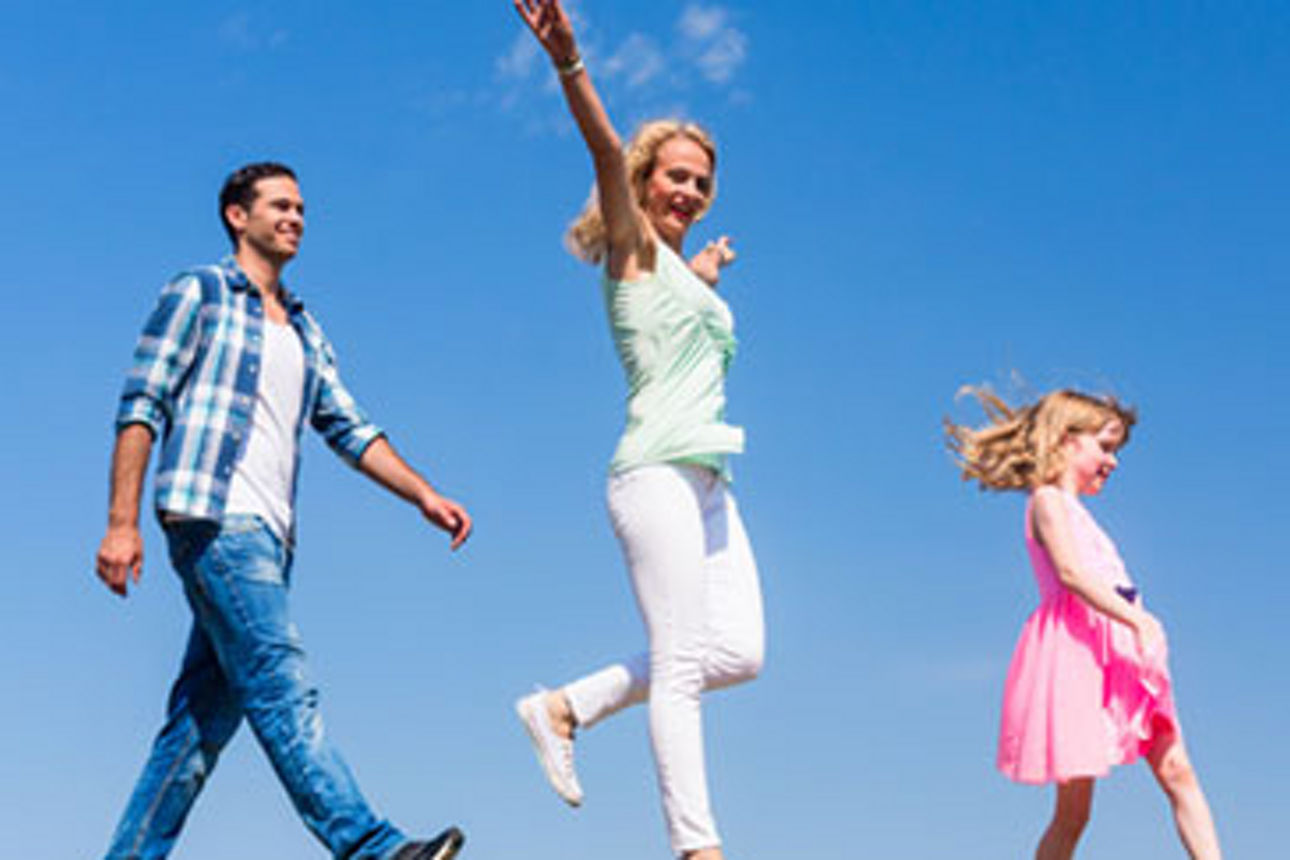 Eine fröhliche Familie springt an einem hellen Tag gemeinsam in die Luft