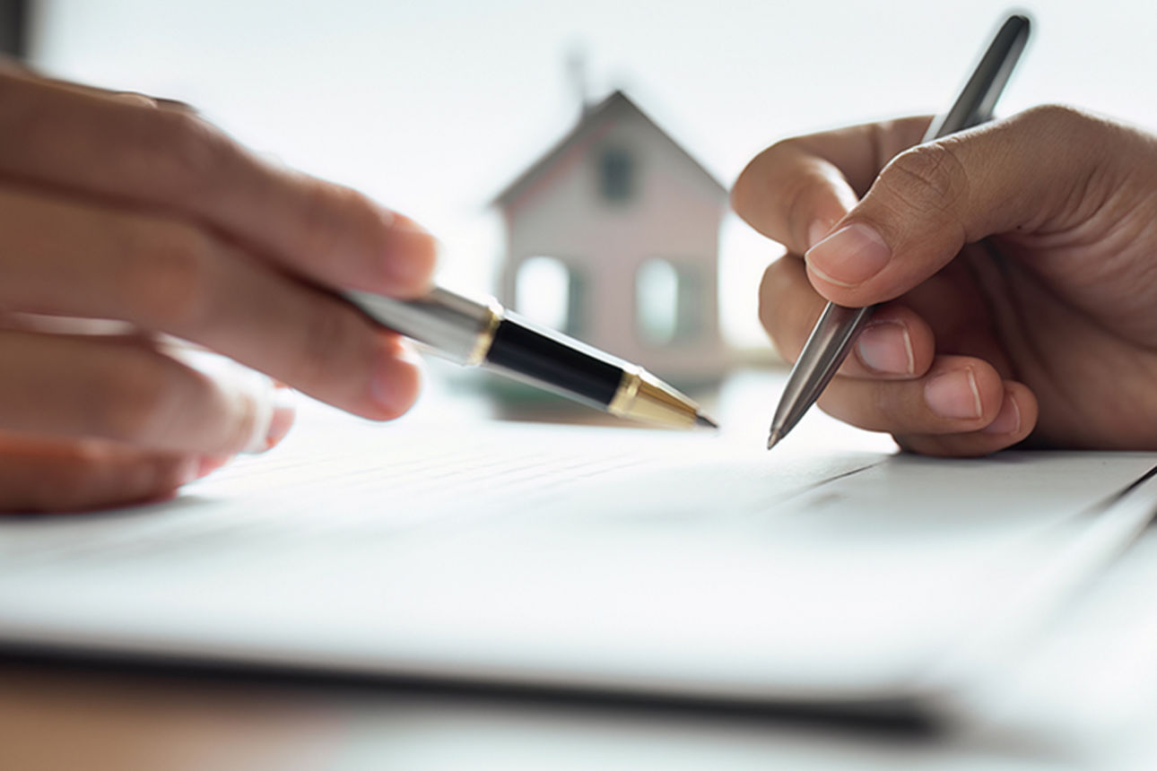 Zwei Personen bei der Vertragsunterzeichnung, Symbolbild für Beratung und Vermittlerbetreuung im Finanzbereich.